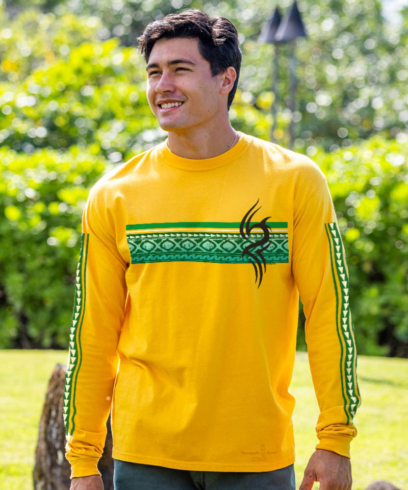 Man wearing a yellow long-sleeve shirt with green accents and a black logo outdoors. View 2