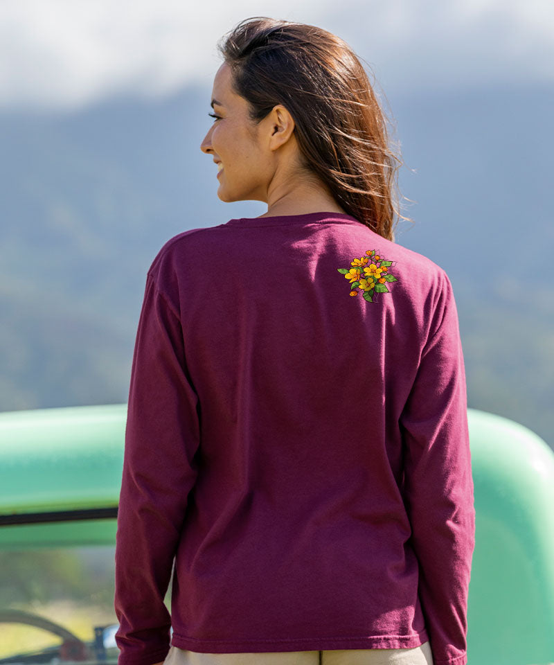 Woman wearing a maroon long-sleeve shirt with a colorful design on the back, standing outdoors. View 3