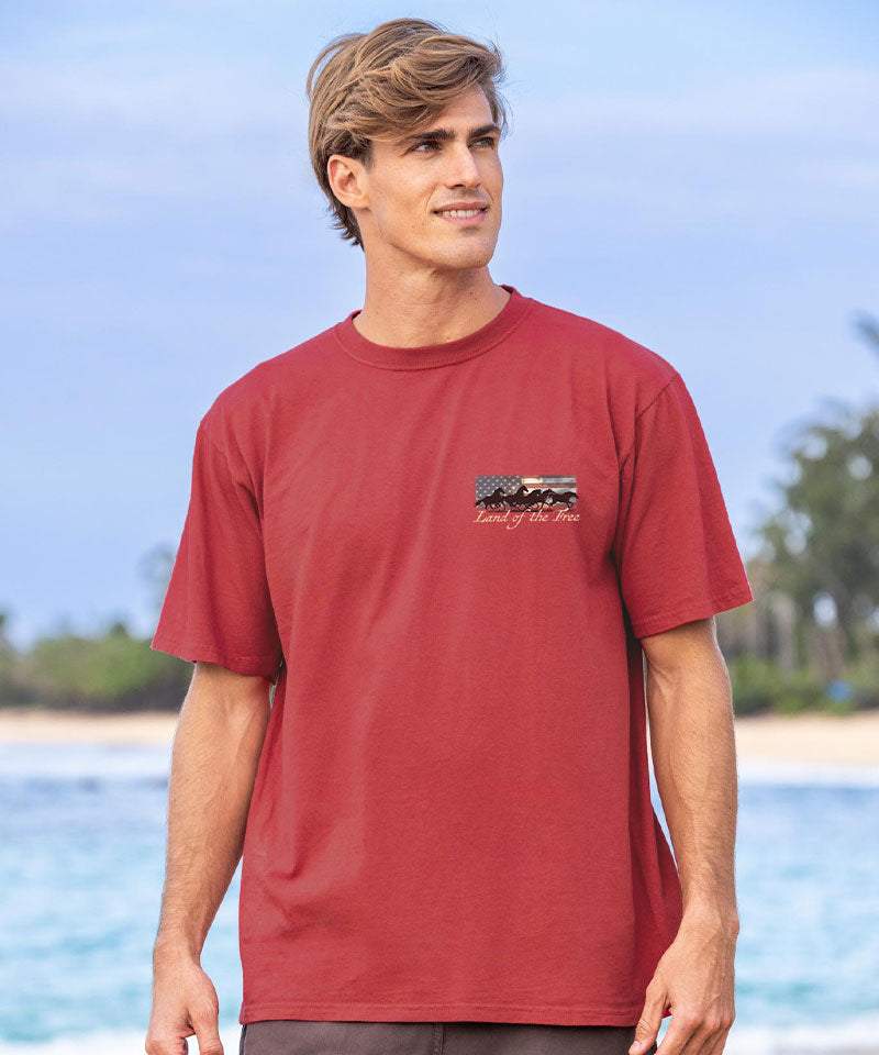 Man wearing a red t-shirt with a logo on a beach View 3