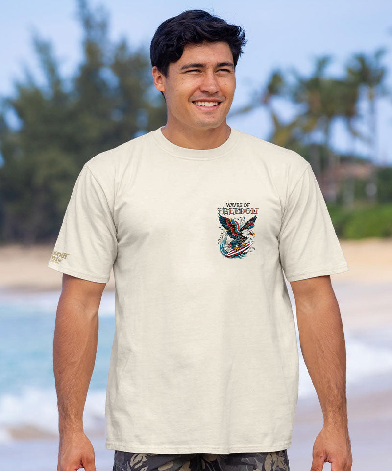 Man wearing a white t-shirt with a colorful graphic on a beach View 3