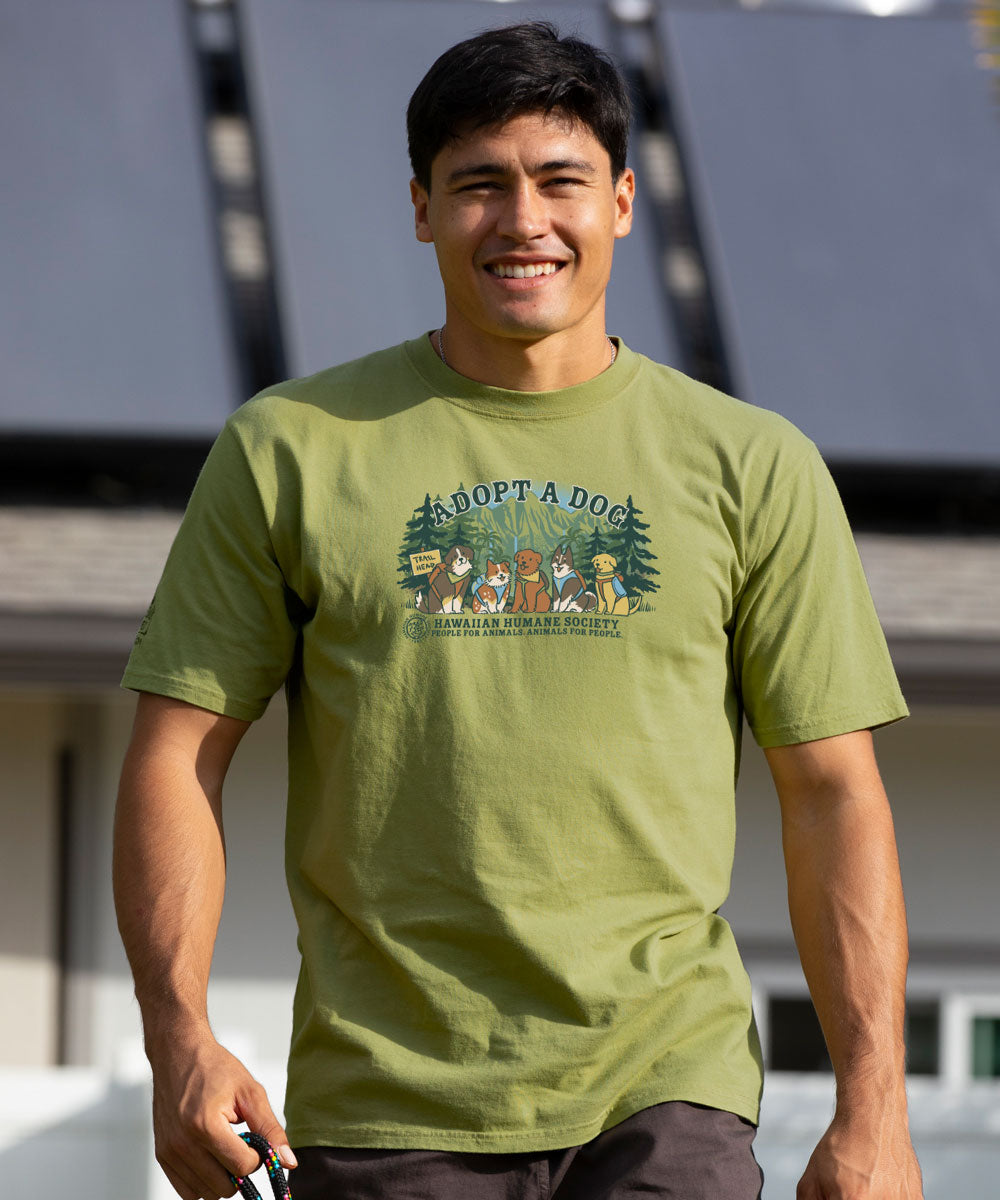 Man wearing a green t-shirt with 'Adopt a Dog' graphic design outdoors. View 2