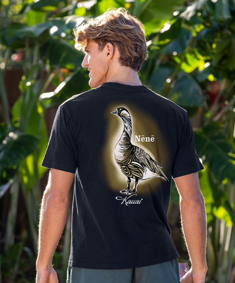 Person wearing a black t-shirt with a bird design and text in a natural setting View 2