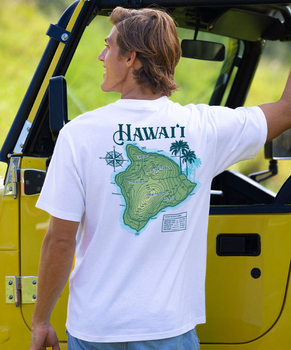 A man wearing a white t-shirt with a green Hawaii map graphic and 'HAWAII' text, standing next to a yellow vehicle outdoors. View 2