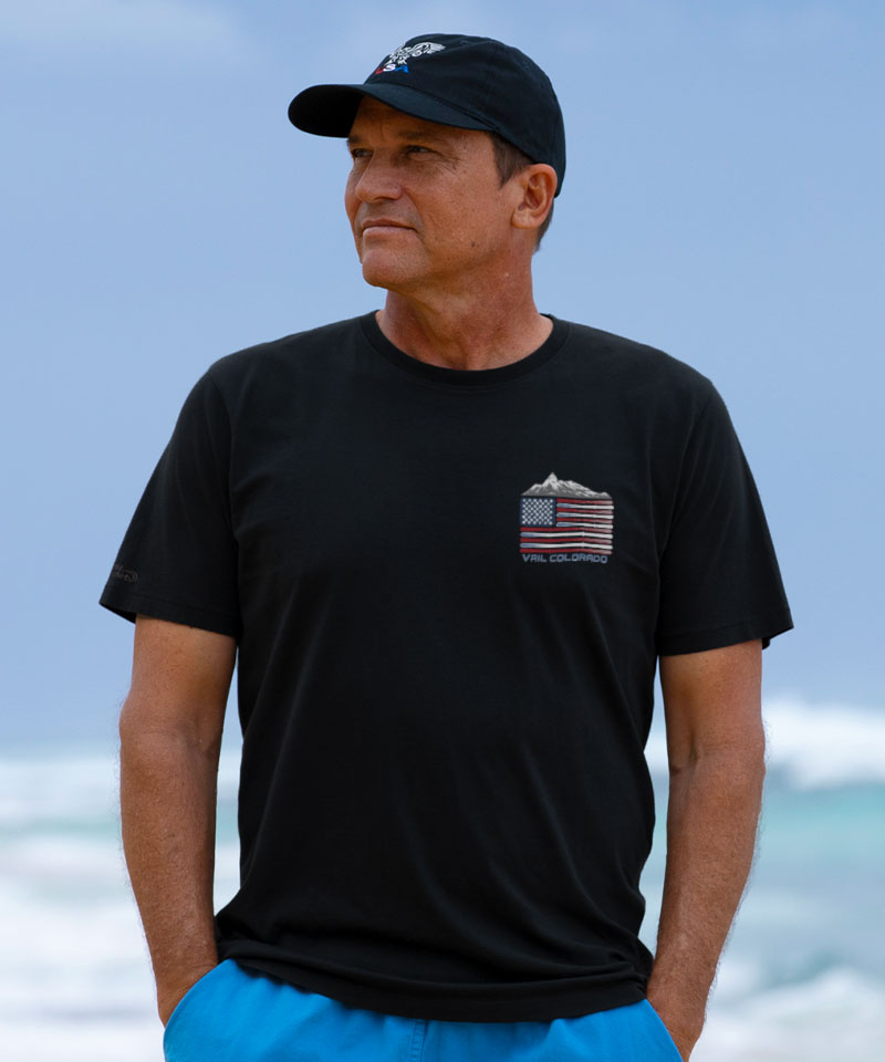 Man wearing a black t-shirt with a graphic design on a beach View 3