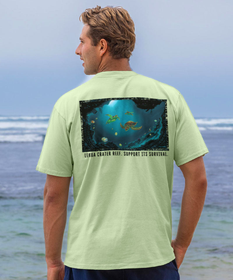 Man wearing a light green t-shirt with a graphic design on the beach