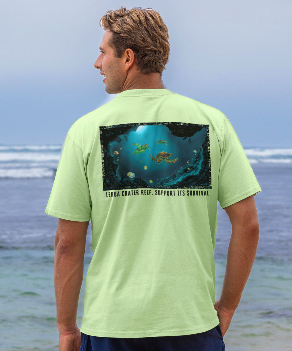 Man wearing a light green t-shirt with a graphic design on the beach View 2