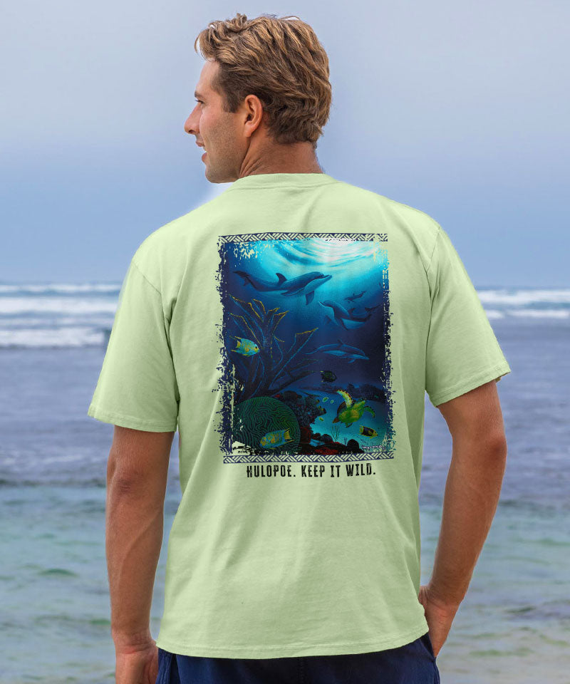 Man wearing a light green t-shirt with an underwater graphic on the beach
