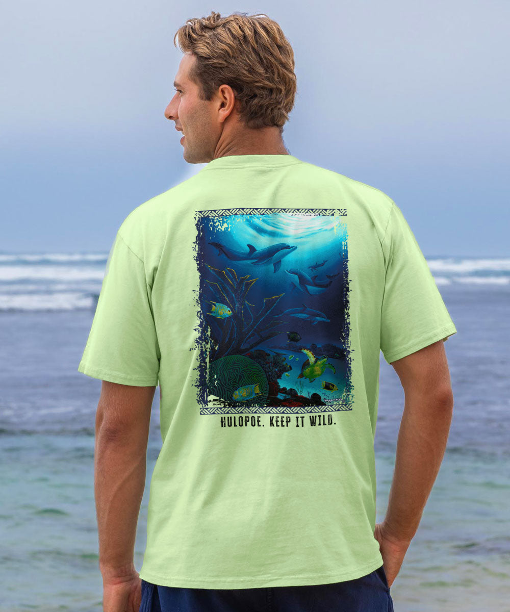 Man wearing a light green t-shirt with an underwater graphic on the beach View 2