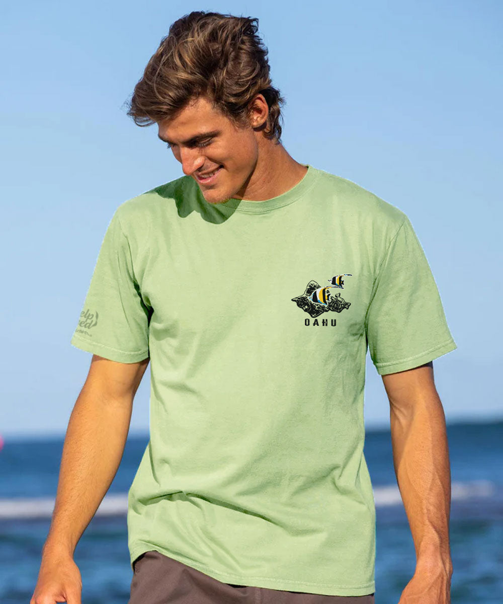 Man wearing a green t-shirt with a logo on a beach View 3