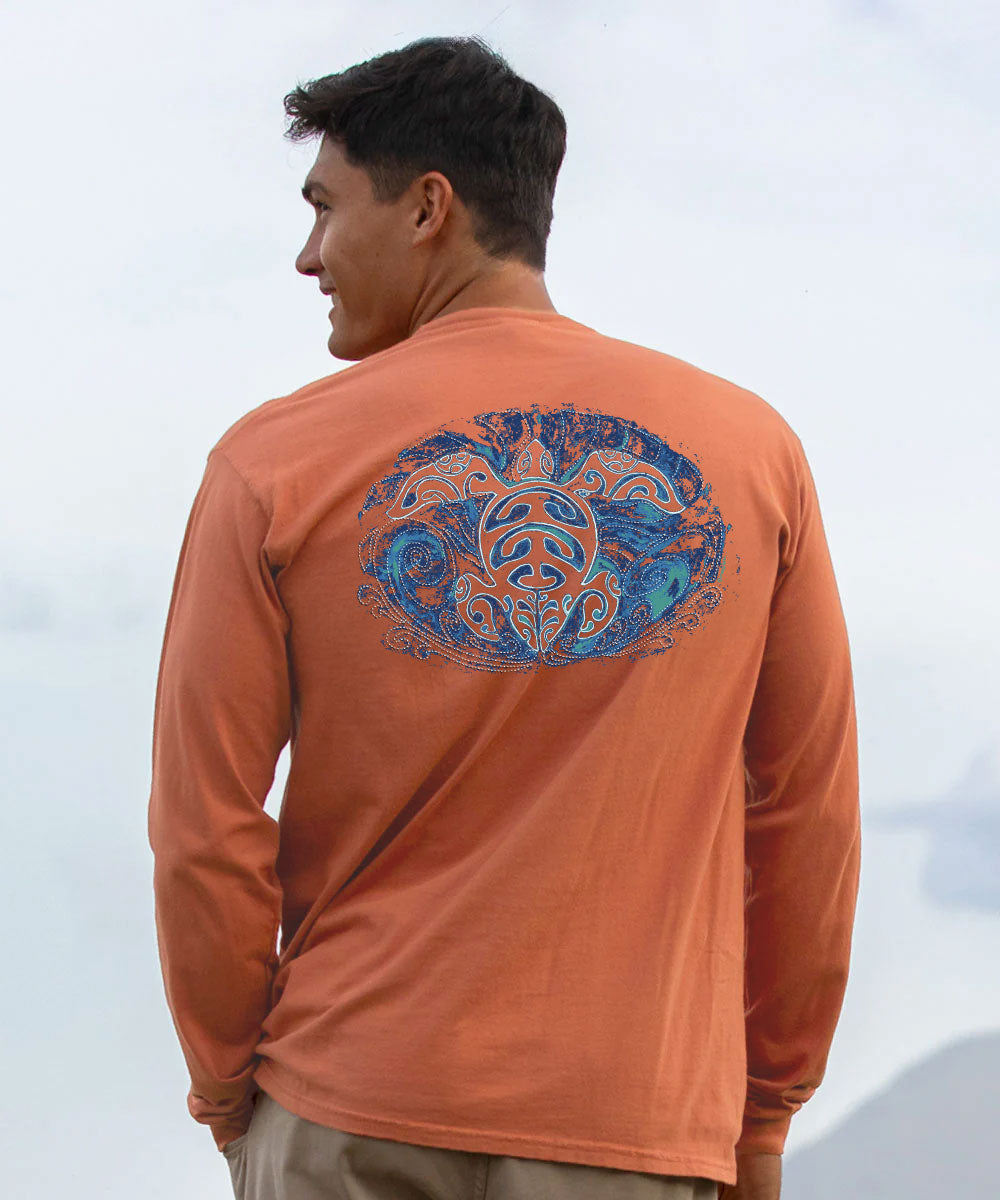 A man wearing an orange long-sleeve performance shirt, viewed from behind to show a large blue and orange graphic print on the back, set against a bright, overcast outdoor background. View 2
