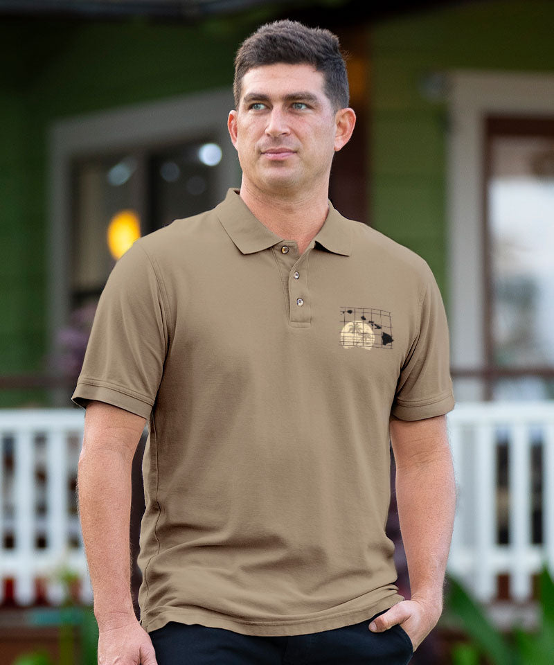 Man wearing a beige polo shirt with a logo, standing outdoors. View 2