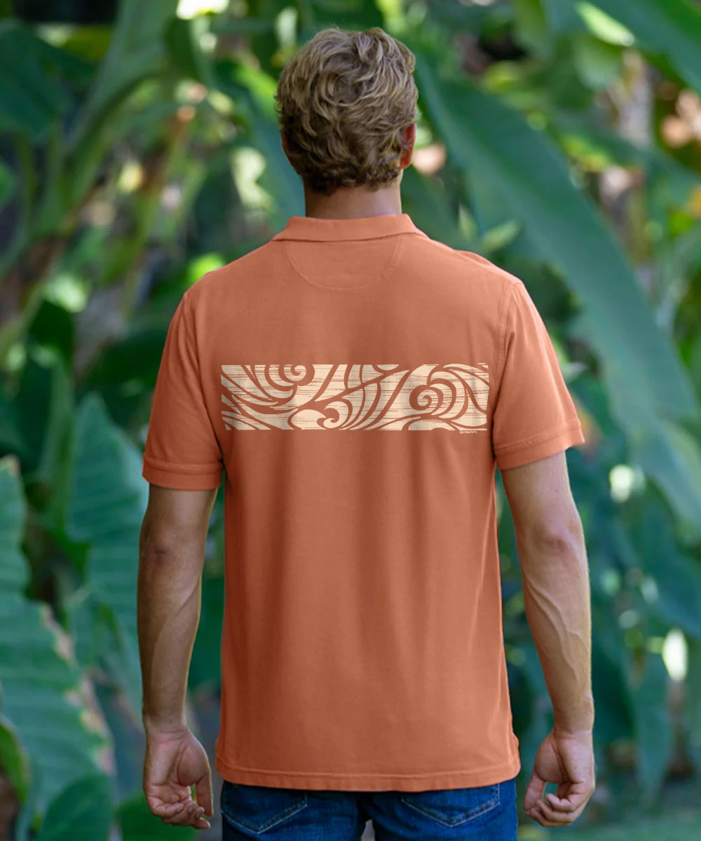 A man viewed from behind wearing a short-sleeve polo shirt in a solid terracotta orange color, set against a lush green tropical foliage background. View 3