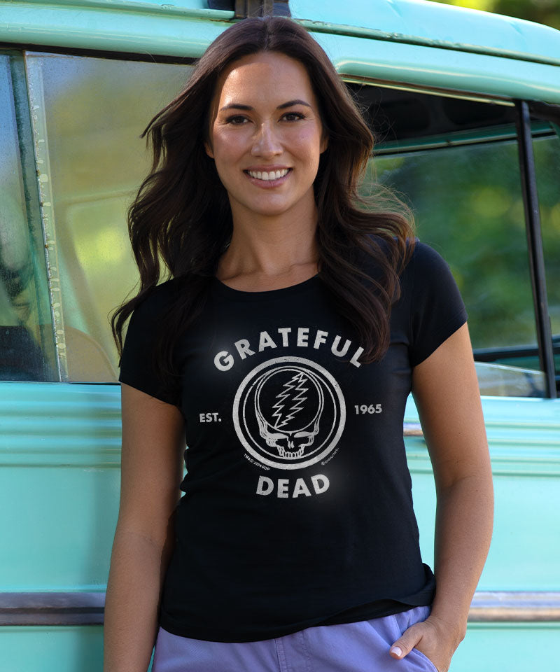 Woman wearing a 'Grateful Dead' t-shirt in front of a teal vehicle. View 2