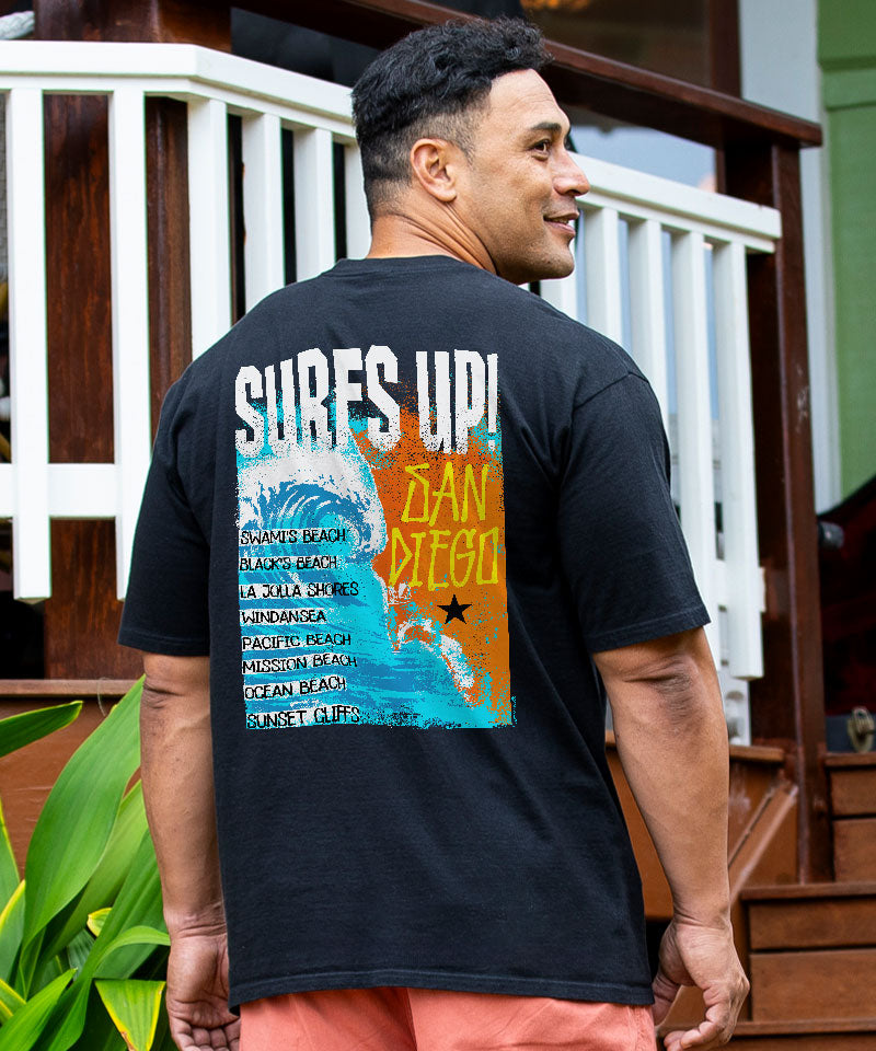 Man wearing a black t-shirt with 'SURFS UP!' design outdoors. View 2