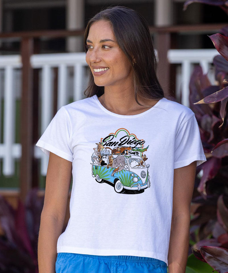 Woman wearing a white t-shirt with a colorful graphic design, standing outdoors. View 2