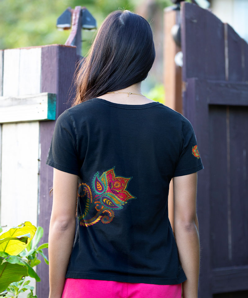 Person wearing a black t-shirt with colorful designs outdoors View 3