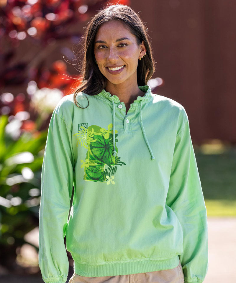 Woman wearing a light green hoodie with a green design outdoors View 2