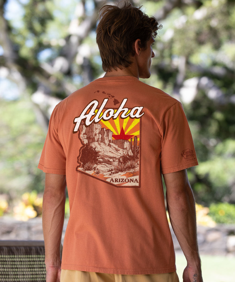 Person wearing a reddish-brown t-shirt with 'Aloha Arizona' design, standing outdoors. View 2