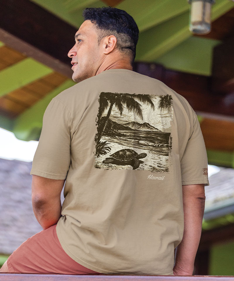 Man wearing a beige t-shirt with a graphic print on a beach View 2