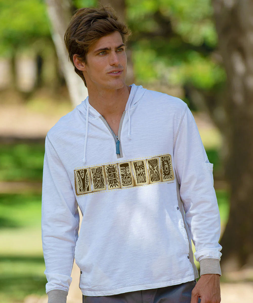 A man wearing a white long-sleeve hooded shirt with a gold-toned decorative graphic across the back, photographed outdoors in a park setting. View 2