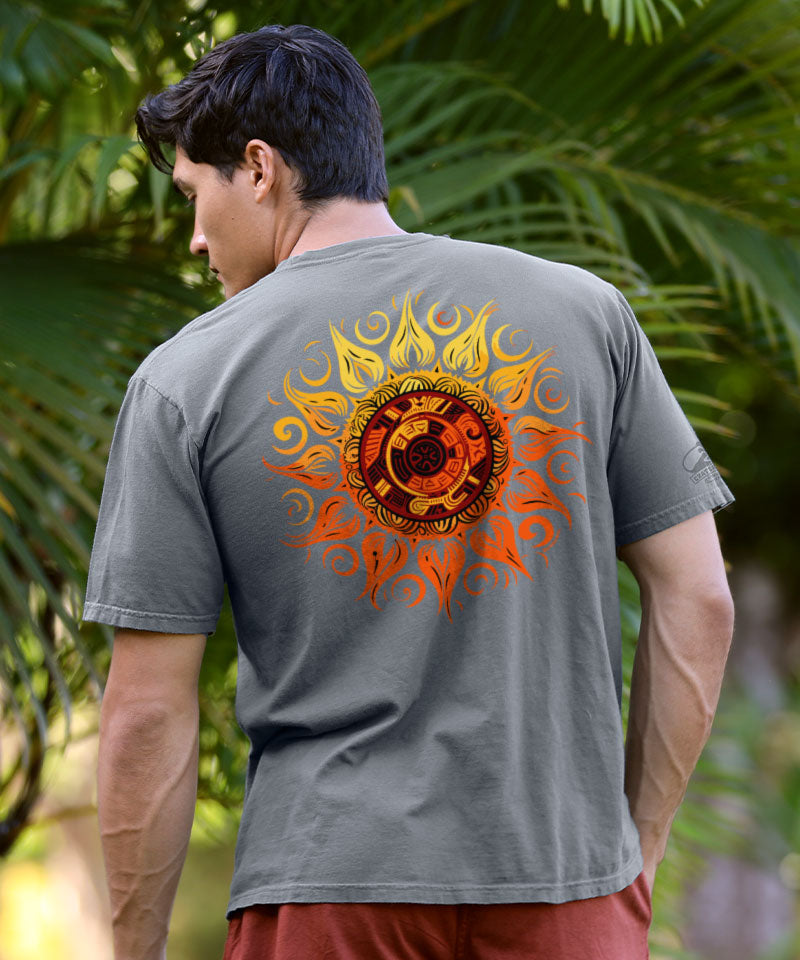 Man wearing a gray t-shirt with a colorful sun design on the back, standing outdoors with greenery in the background. View 2