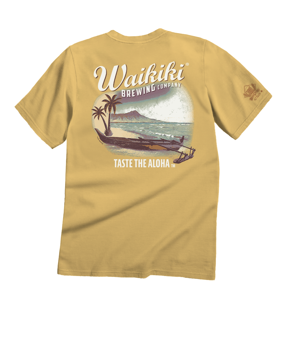 A mustard yellow t-shirt shown from the back, featuring a large graphic print of a Waikiki Beach scene with a traditional canoe, palm tree, and volcano, with 'Waikiki Brewing Company' and 'TASTE THE ALOHA' text. View 1