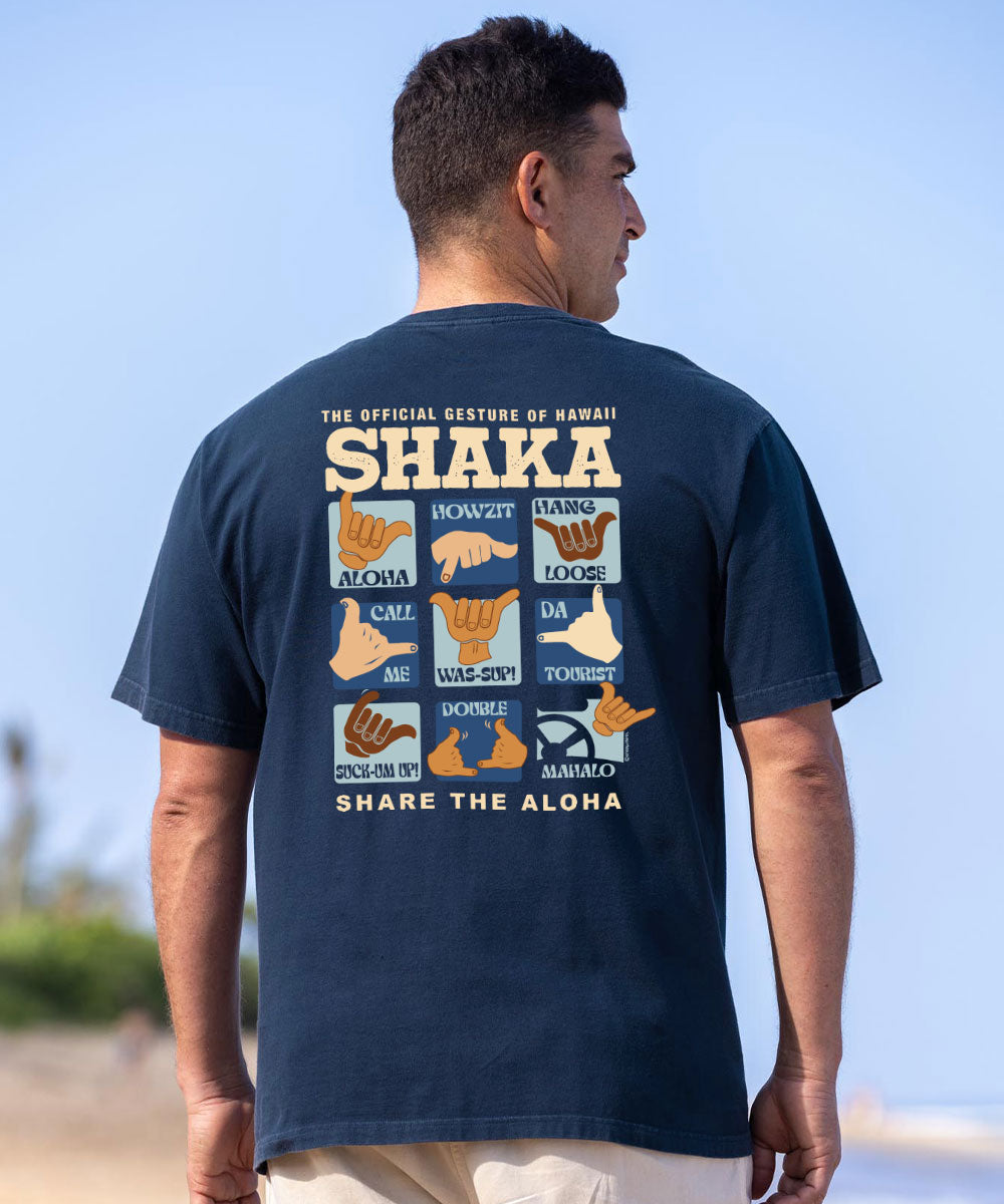A man wearing a navy blue t-shirt with a large graphic print on the back, photographed from behind on a beach with a blue sky background. View 2