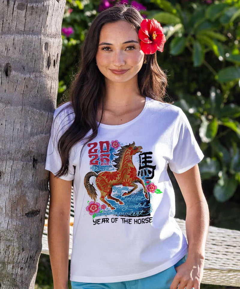 Woman wearing a white t-shirt with a horse graphic and text, standing outdoors. View 2