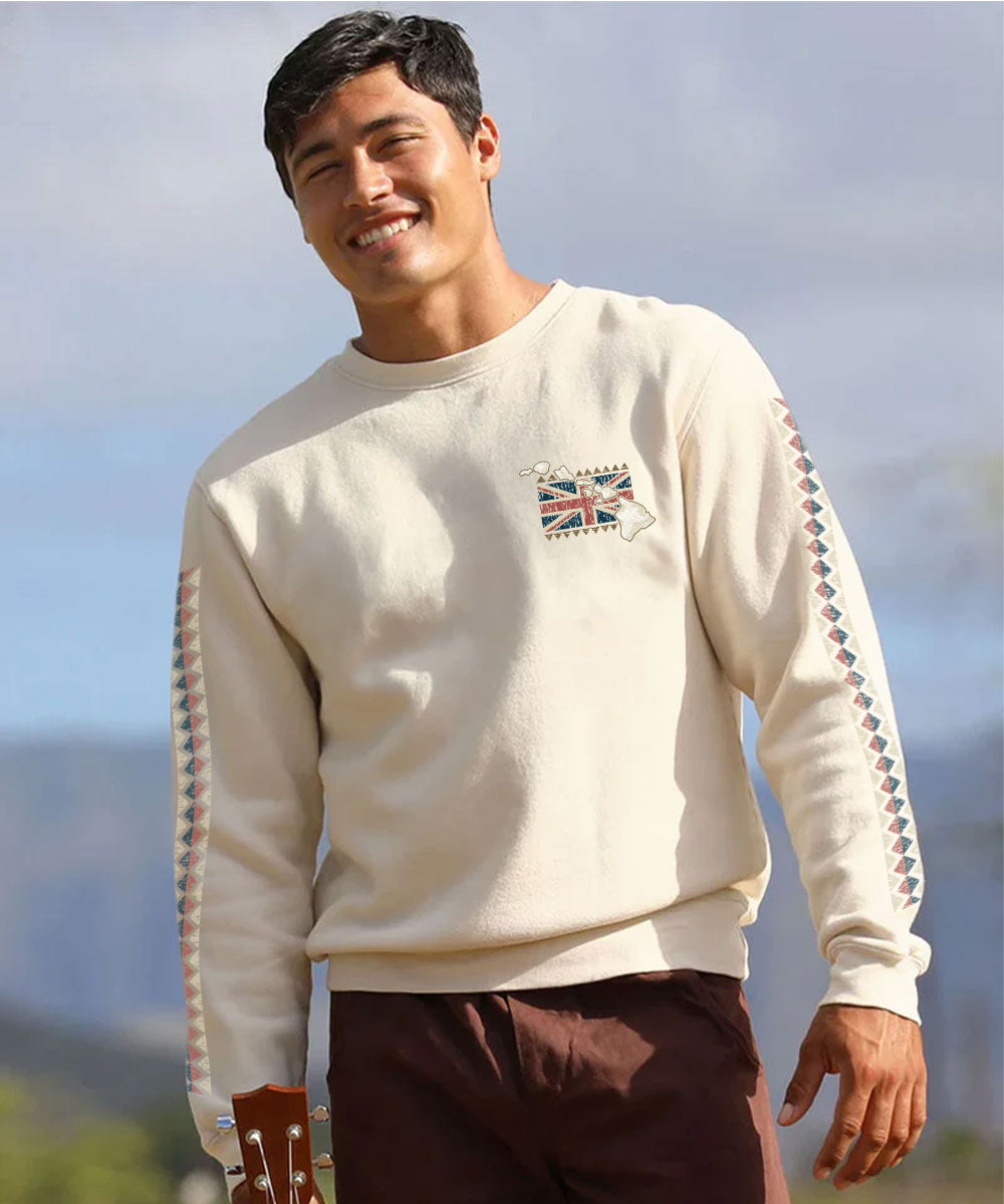 Man wearing cream colored sweater with a small pocket print of the hawaiian flag and sleeve designs standing outside View 3