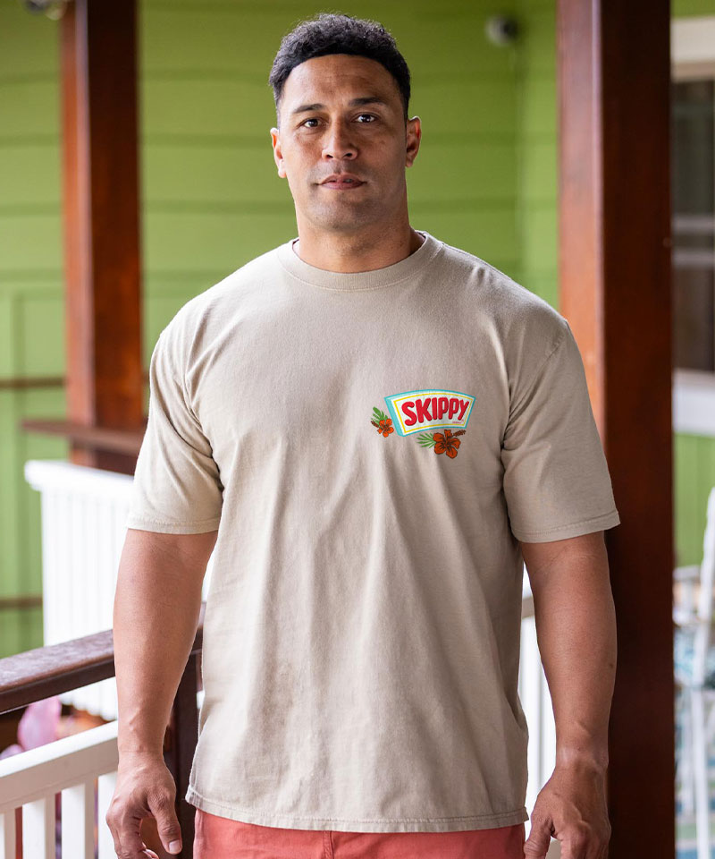 Man wearing a beige t-shirt with Skippy peanut butter logo on a wooden porch. View 3