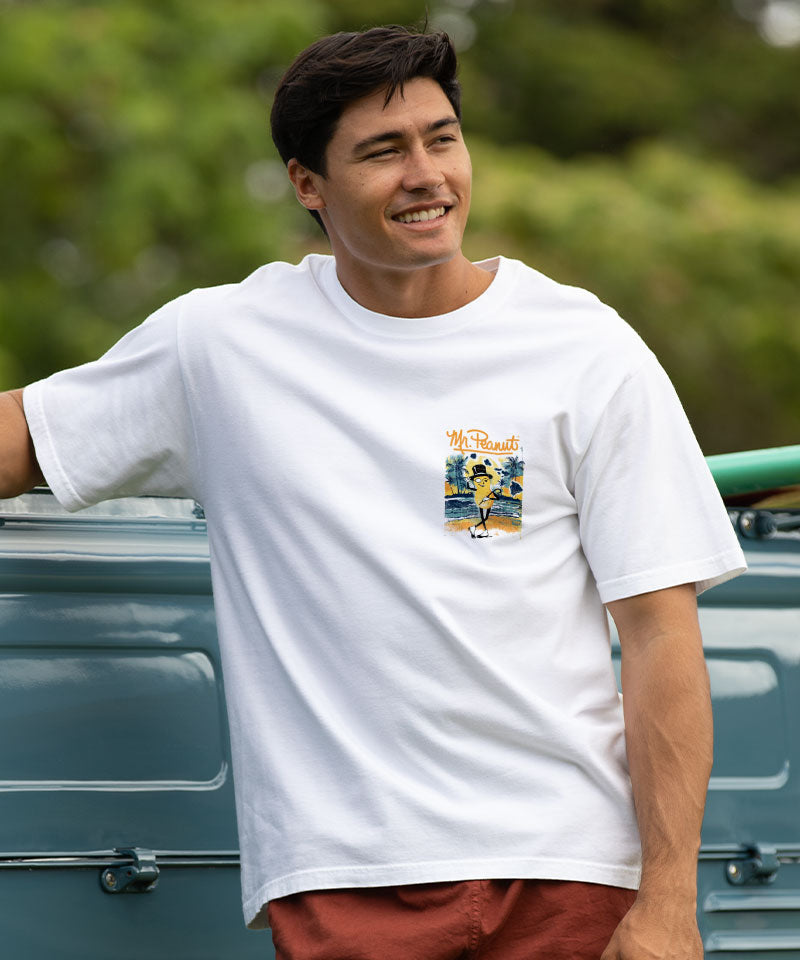 Man wearing a white t-shirt with a graphic design, standing next to a truck outdoors. View 3