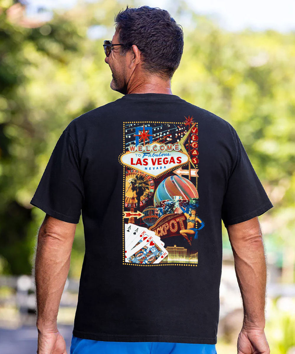 A man viewed from behind wearing a black t-shirt with a large, colorful 'Welcome to Las Vegas' graphic print on the back, set against a blurred outdoor background. View 2