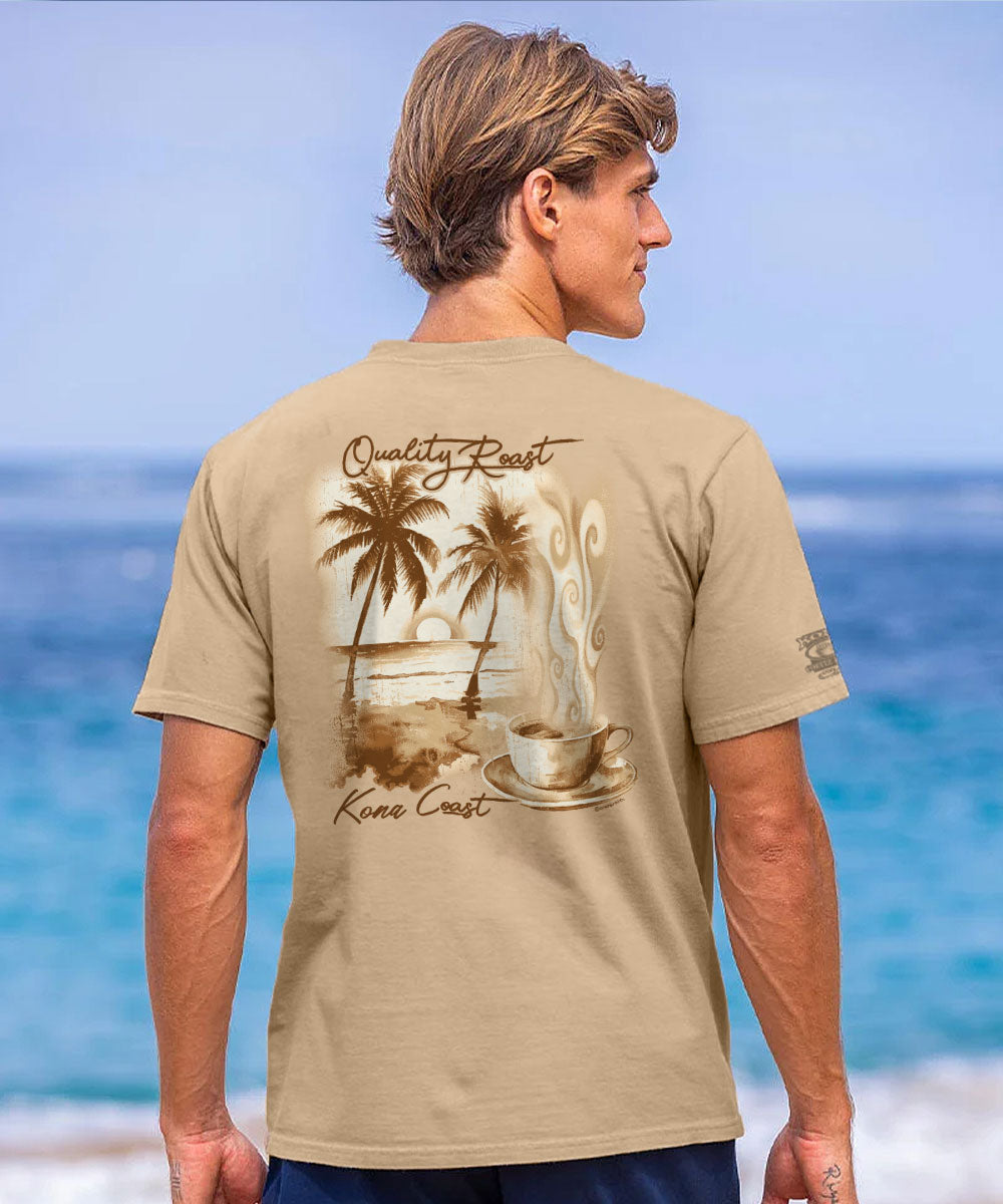 A man wearing a beige t-shirt with a tropical beach graphic on the back, standing against a blurred ocean background. View 2
