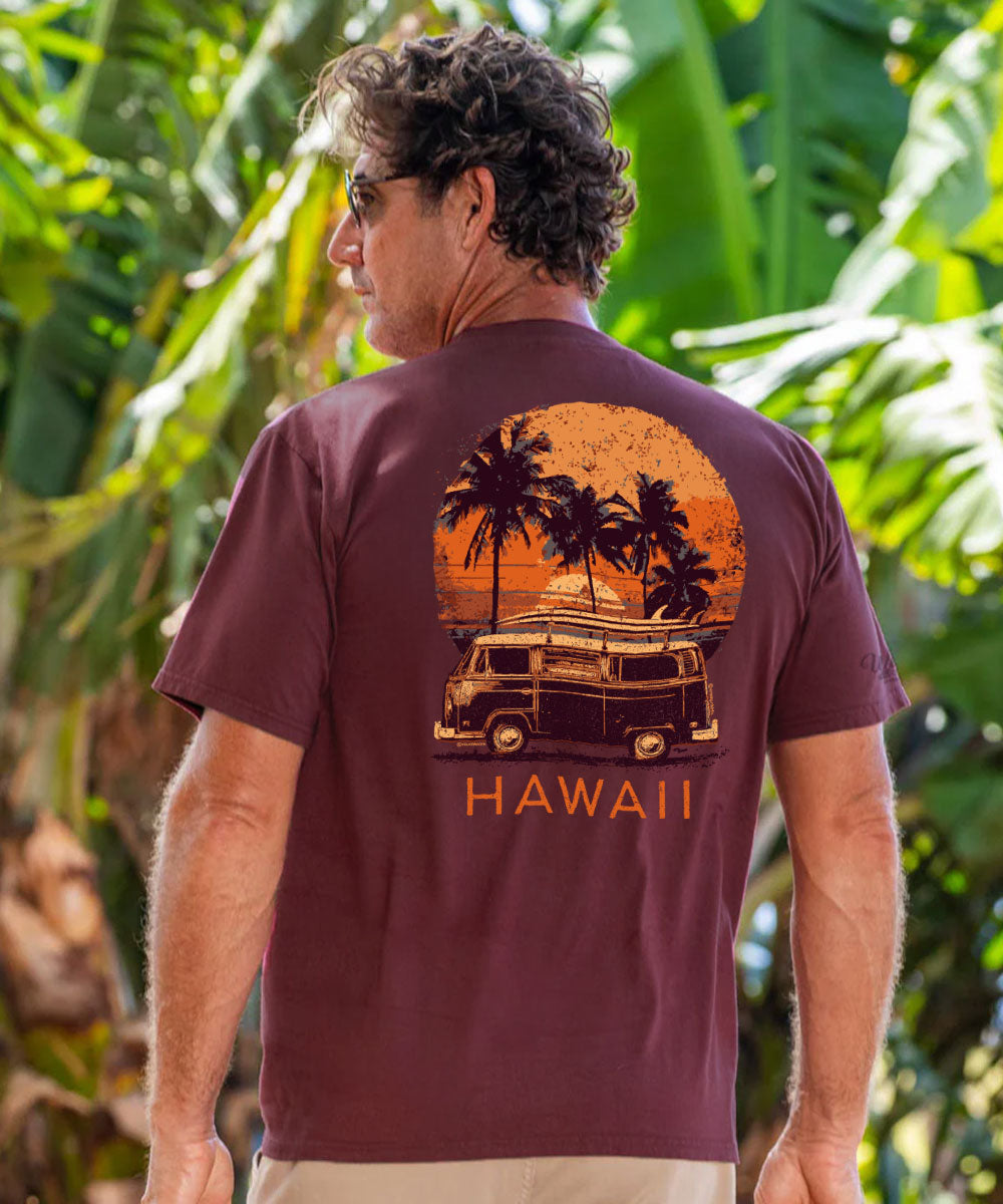 A man wearing a maroon short-sleeve t-shirt with a retro-style Hawaii graphic on the back, featuring a surfboard on a van, palm trees, and an orange sunset. The word 'HAWAII' is printed below the graphic. View 2