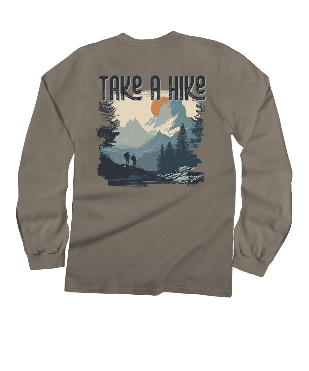 A taupe long-sleeve t-shirt shown from the back, featuring a graphic print of a mountain landscape with the text 'TAKE A HIKE' above it. View 1