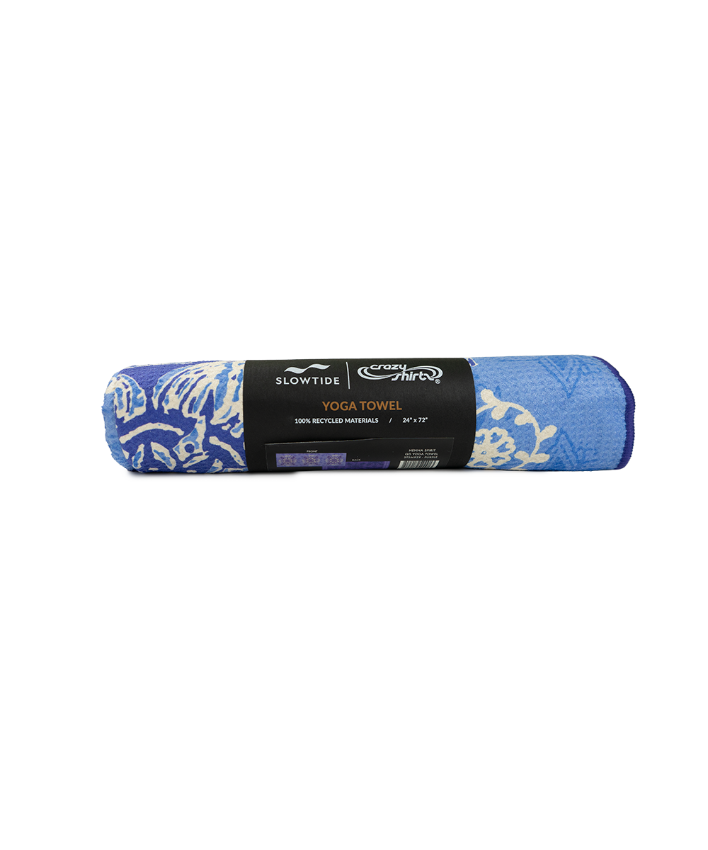 A rolled-up blue and white patterned yoga towel with a black paper label in the center, photographed on a plain white background. View 3