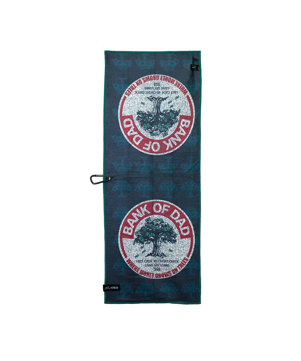 A dark teal golf towel featuring two circular 'Bank of Dad' tree logos, shown flat against a white background with a black carabiner clip attached. View 1