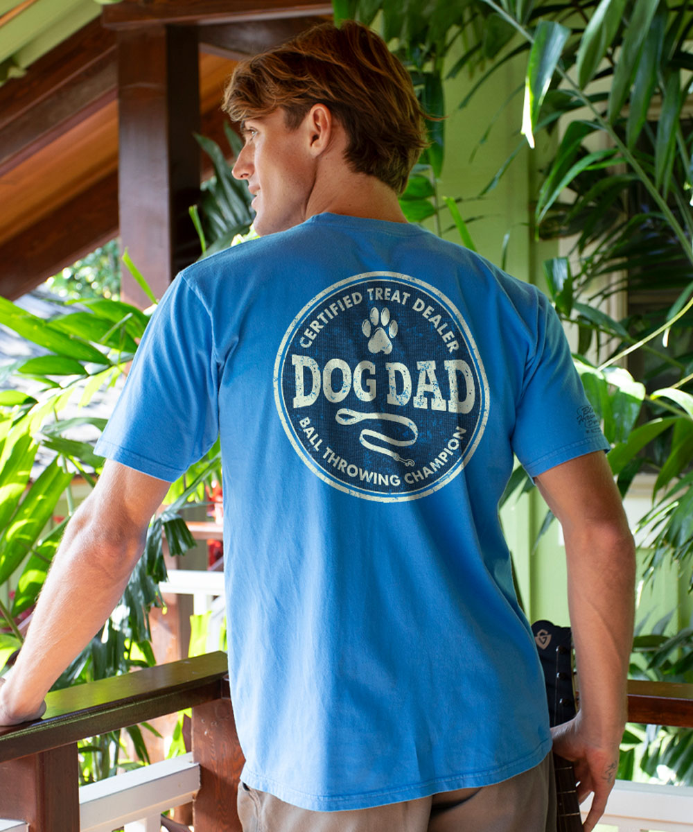 Man wearing a blue t-shirt with 'Dog Dad' text on the back, standing outdoors. View 2