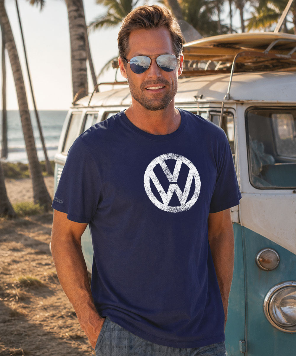 Man wearing a navy blue Volkswagen t-shirt in front of a vintage van.