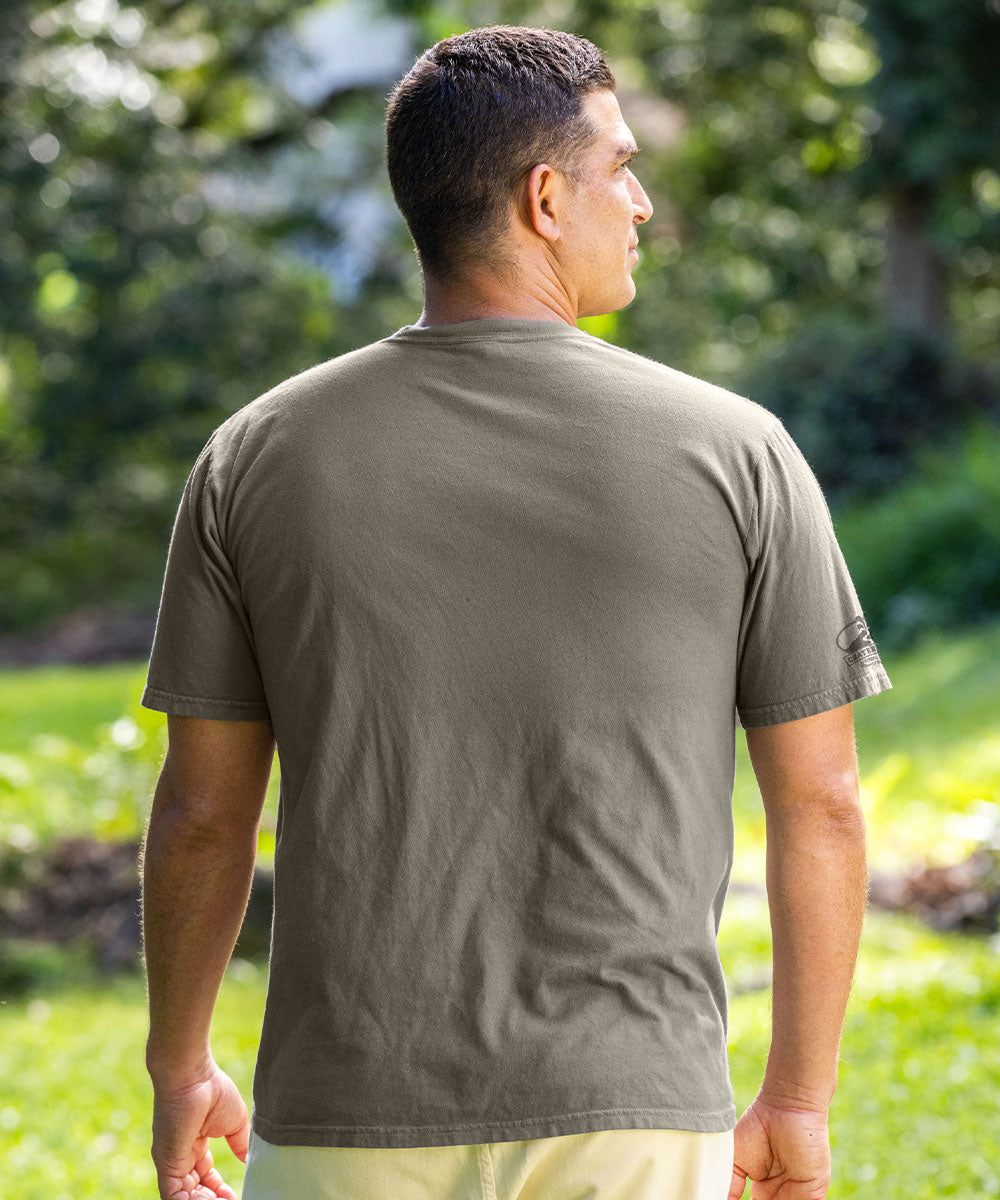 Man wearing a green t-shirt standing outdoors with trees in the background View 3
