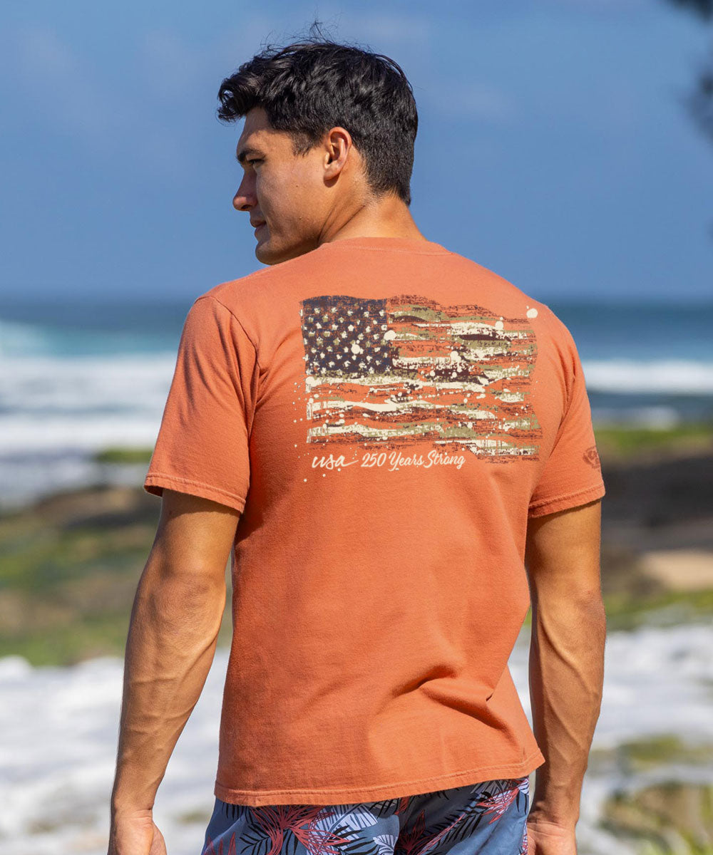 Man wearing an orange t-shirt with a graphic design on the beach View 2