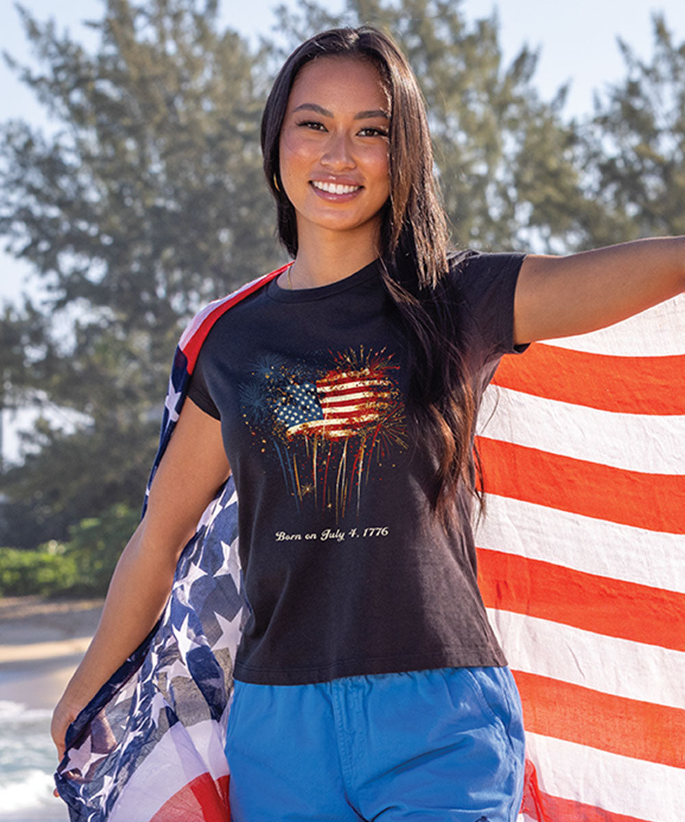 Woman holding an American flag with a black t-shirt featuring an American flag design.