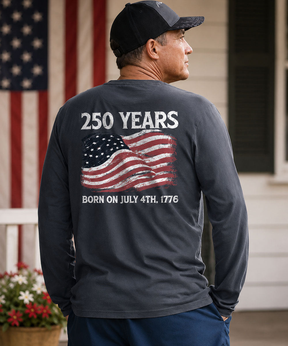 Man wearing a long-sleeve shirt with '250 Years Born on July 4th, 1776' text and American flag design. View 2