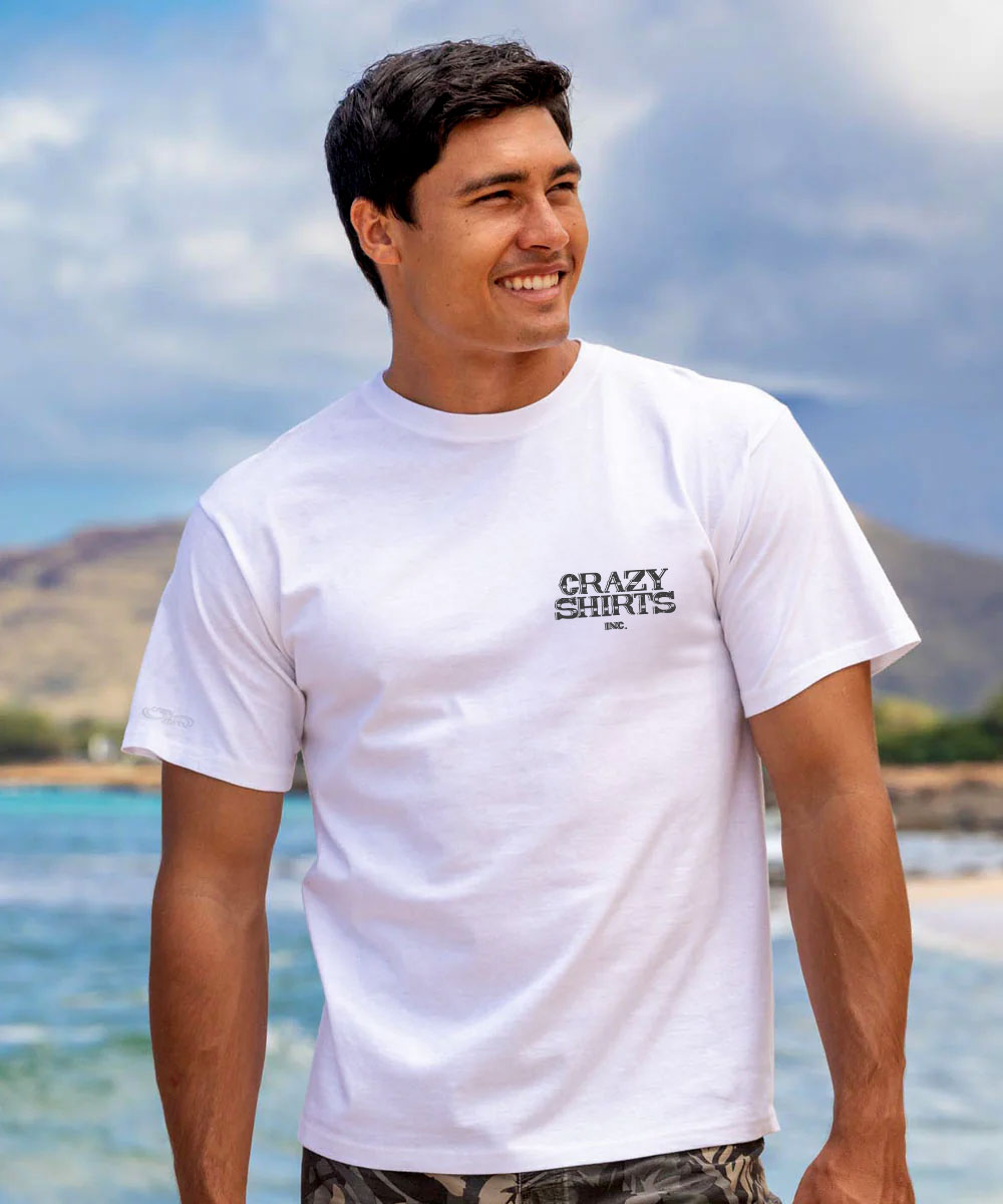 Man wearing a white t-shirt with 'Crazy Shirts' text at the beach View 3