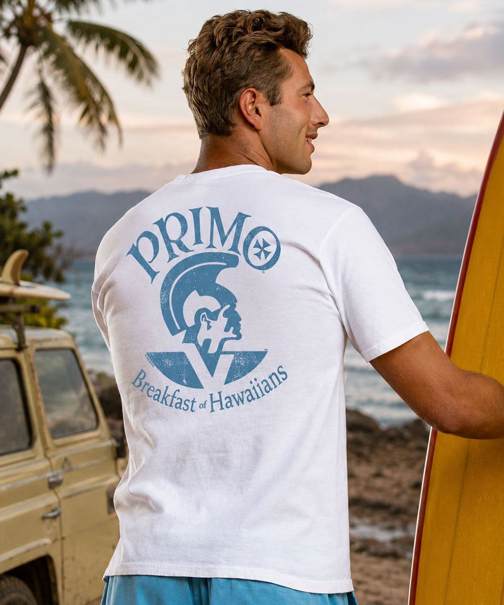 Man wearing a white t-shirt with 'Primo' logo, standing next to a yellow surfboard. View 2
