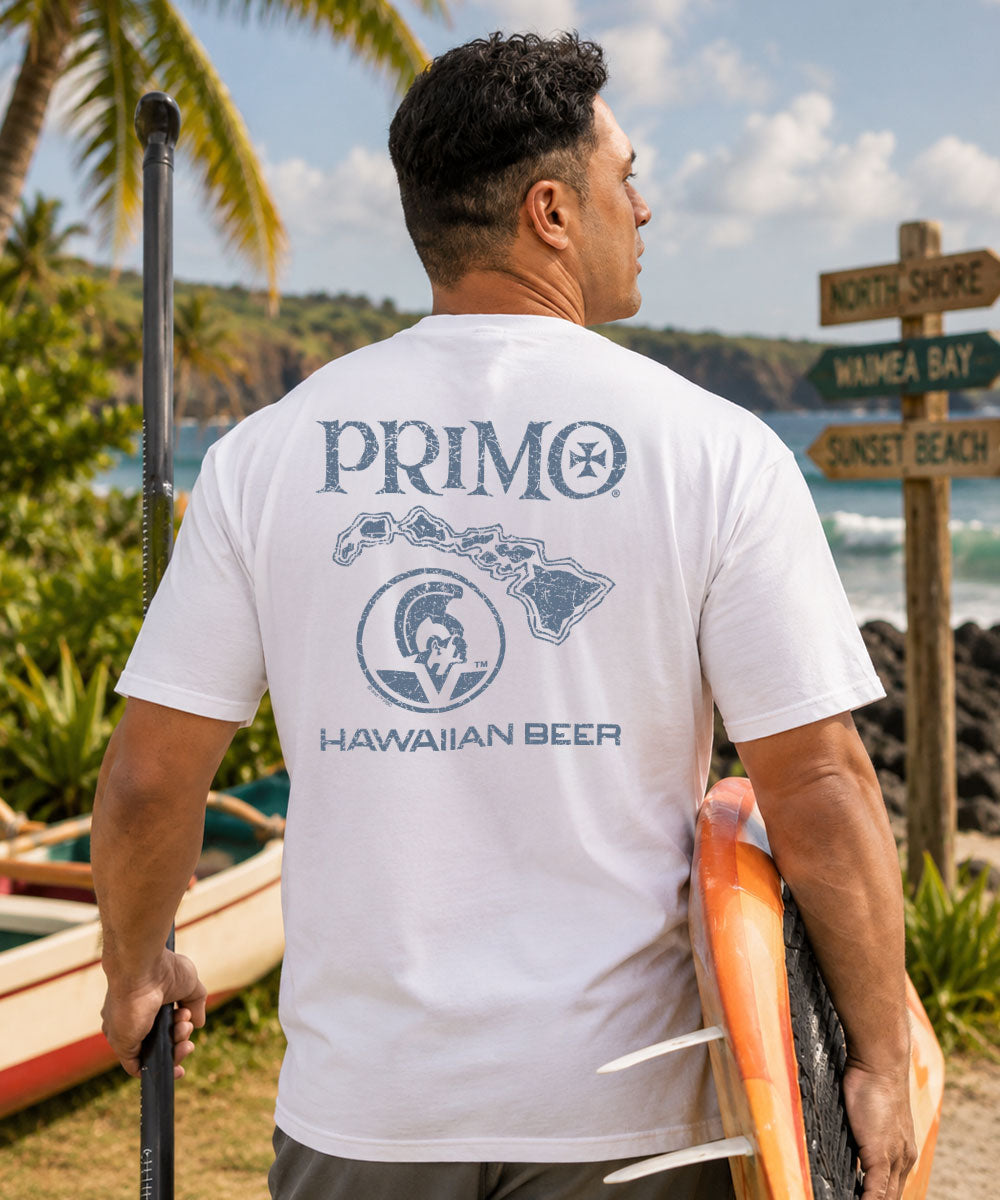 Man wearing a white t-shirt with 'Primo Hawaiian Beer' logo outdoors.