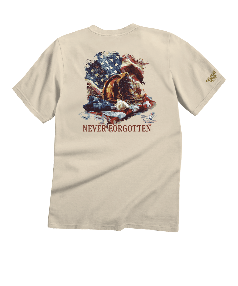 A beige short-sleeve t-shirt shown from the back, featuring a large graphic print of a military combat helmet surrounded by an American flag and the text 'NEVERFORGOTTEN' in red. A small gold logo is printed on the left sleeve. View 1