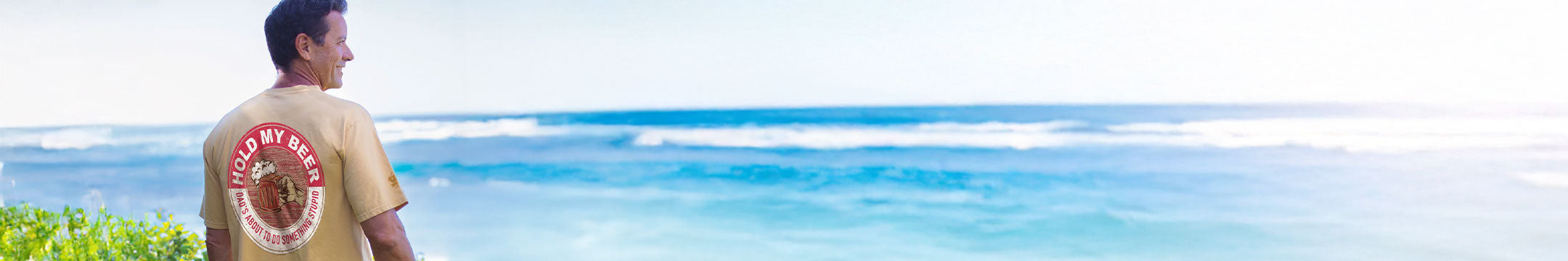 Man wearing a 'Good Life' t-shirt with a tropical beach background