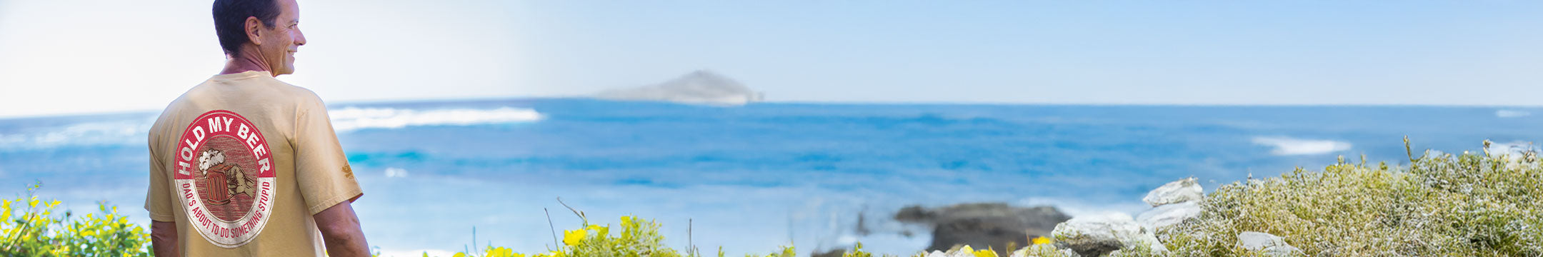 Man overlooking the ocean wearing a beer dyed crazy shirts short sleeve crewneck tee shirt
