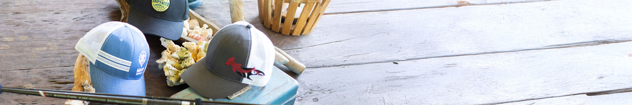 Two baseball caps on a wooden surface with a basket in the background